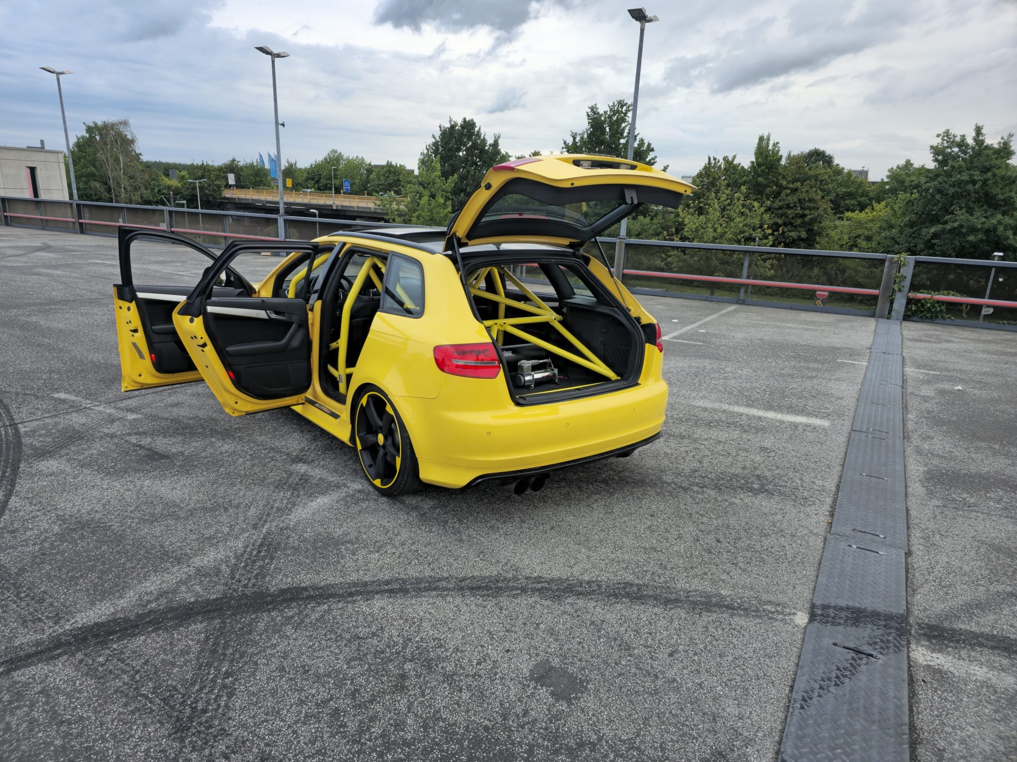 Gelber Audi S3 8P mit geöffneten Türen und sichtbarem Überrollkäfig